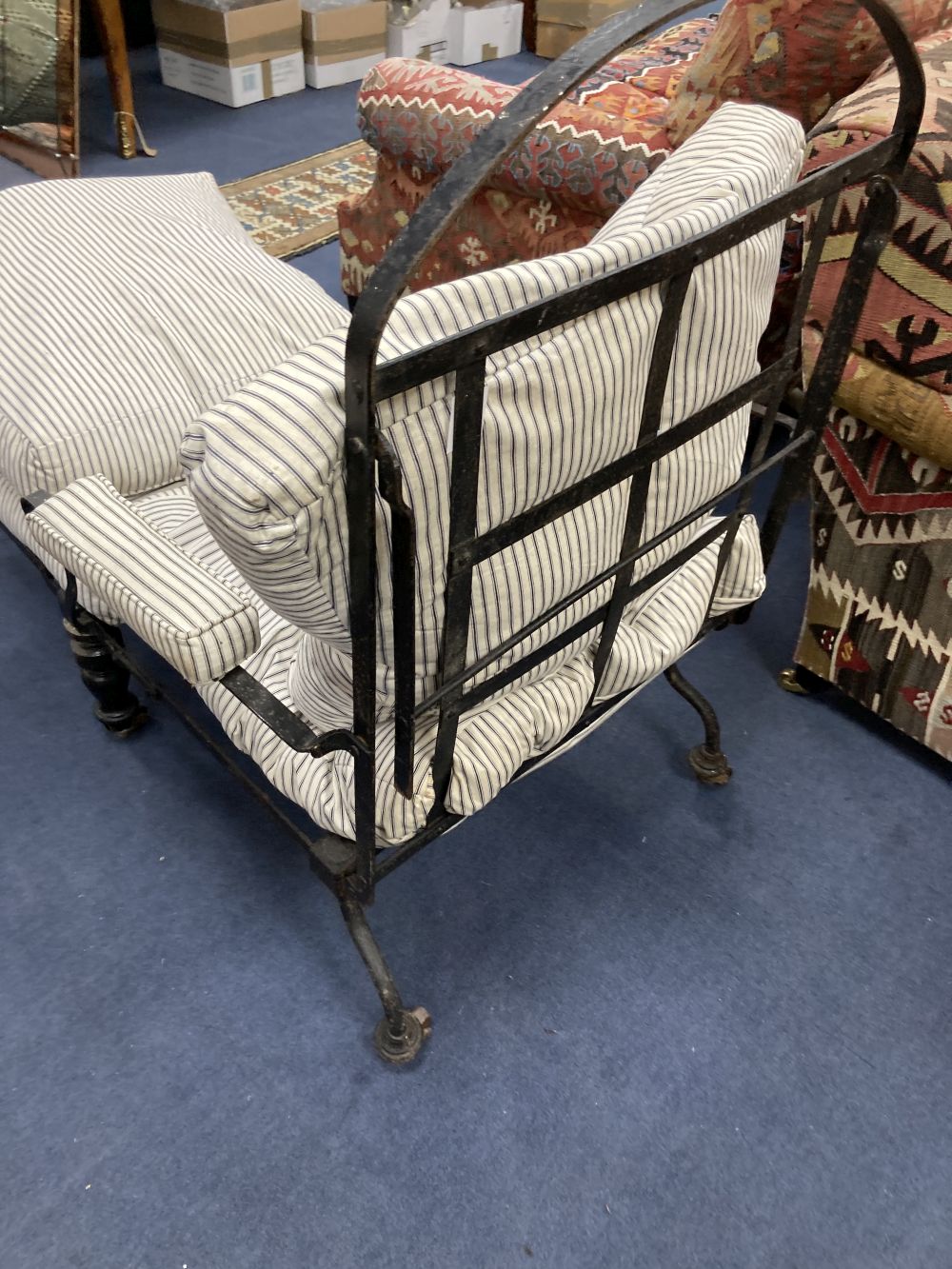 A Victorian wrought iron folding armchair with loose cushion seat and back